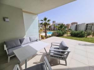 a patio with a couch and a table and chairs at Lightoasis Oasis Mar 3 in Portimão