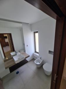 a white bathroom with two sinks and a toilet at Lightoasis Oasis Mar 3 in Portimão +4 photos
