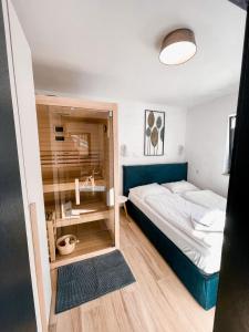 a bedroom with a bed and a glass wall at Sunshine Apartments Golte - Sauna in Mozirje