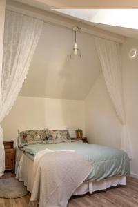 - une chambre avec un lit et des rideaux blancs dans l'établissement Villa intill naturreservat, à Ryssby