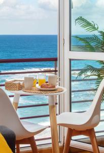una mesa con comida y bebida en un balcón con vistas al océano en AG Miramar Malpica x4 vistas playa Costa da Morte, en Malpica de Bergantiños
