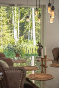 Cette chambre dispose de tables et d'une grande fenêtre avec des arbres. dans l'établissement Villa intill naturreservat, à Ryssby