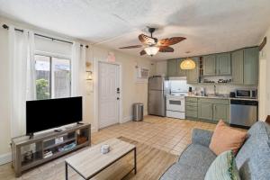 a living room with a couch and a tv and a kitchen at Beach Bungalows By The Sea 3 in Cocoa Beach