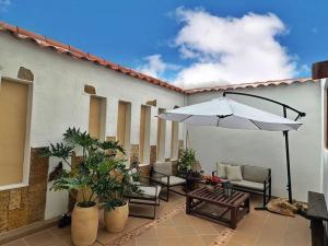 Casa Oasis - Centro histórico ( Pocos pasos de la plaza principal) في فيلا دي ليفا: فناء مع طاولة ومظلة