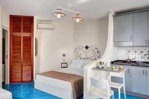 een kleine slaapkamer met een bed en een keuken bij Vera ed il Vervece by Gocce On the Sea in Massa Lubrense
