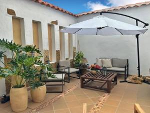 Casa Oasis - Centro histórico ( Pocos pasos de la plaza principal) في فيلا دي ليفا: فناء مع طاولة ومظلة