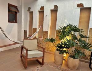 Casa Oasis - Centro histórico ( Pocos pasos de la plaza principal) في فيلا دي ليفا: كرسي جالس في غرفة فيها نباتات