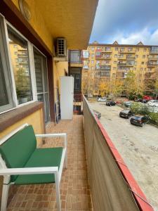 a balcony with a green bench on a building at Comfort Stay Apartment - Free Parking & Wi-Fi in Chiajna