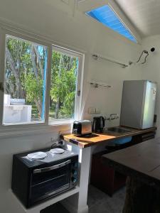a small kitchen with a microwave and a sink at El LUCERITO in Mar de Ajó