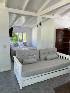uma sala de estar com um sofá e uma cama em El LUCERITO em Mar de Ajó