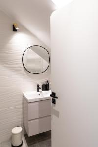 une salle de bain avec un lavabo et un miroir dans l'établissement Studio 8 I One Bedroom Apartment I Airport I Therme, à Otopeni