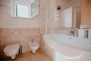 un bagno con una vasca bianca e un water di Tenuta Matilda by TripOstuni a Ostuni Altre 34 foto