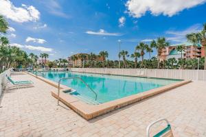 a swimming pool at a resort with palm trees at Sunrise haven in Clearwater Beach