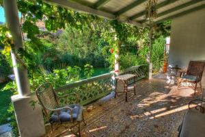 a porch with chairs and a table and trees at La Petite Calanque in Marseille