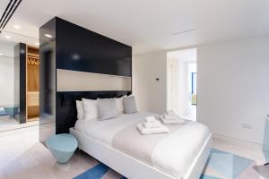 a bedroom with a large white bed with a black headboard at Designer Apartment in Mayfair/Regent Street in London