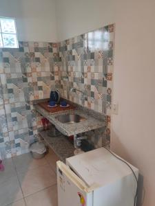 uma cozinha com um lavatório e um frigorífico em Moradas Vô Ary em Garopaba