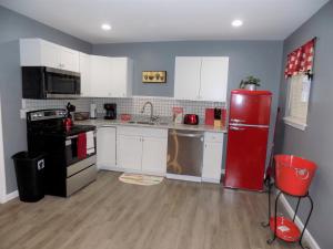 a kitchen with a red refrigerator and white cabinets at Fishing Retreat in Pensacola