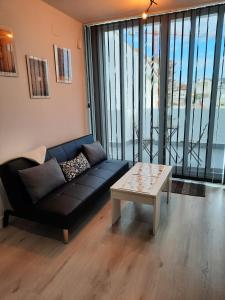 a living room with a couch and a coffee table at Ático centro Huelva con parking in Huelva