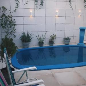 a swimming pool with a chair and potted plants at Casa em João Pessoa Paraíba in João Pessoa