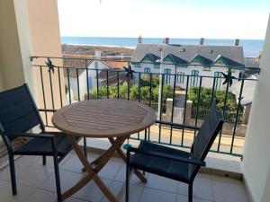 a table and chairs on a balcony with a view of the ocean at Superbe duplex accès et vue mer, garage, linge fourni in Saint-Hilaire-de-Riez