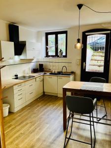 a kitchen with white cabinets and a table and a dining room at Zentrales und ruhiges Apartment im beliebtesten Bremer Viertel in Bremen