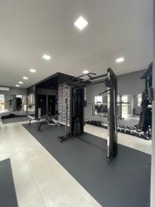 a gym with treadmills and machines in a room at Apartamento completo para veraneio in Torres