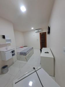 Cette chambre blanche comprend un lit et un lavabo. dans l'établissement 3D Hotel, à Manaus