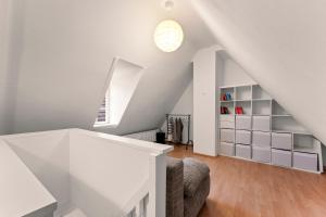 a white attic room with a couch and a window at Charmante Maisonette im Schnoor in Bremen