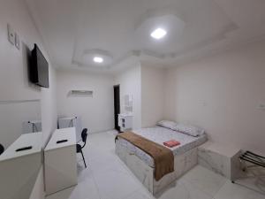 a bedroom with a bed and a desk and a tv at 3D Hotel in Manaus