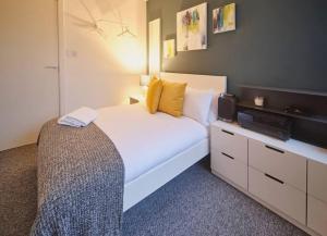 een slaapkamer met een wit bed en een televisie bij Glasgow, Finnieston Luxury 2 Bed with parking, e-check in, hi-fi in Glasgow