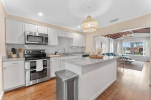 a kitchen with white cabinets and a stove top oven at Redington Beach Bungalow in St Pete Beach