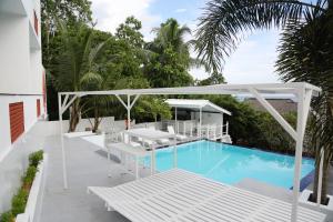 a patio with a pool and a white canopy and chairs at Talalla Leisure in Talalla South
