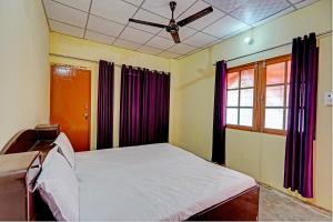 a bedroom with a bed and a ceiling fan at OYO Vashudev Garden in Bijnor