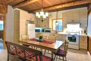 a kitchen with a dining room table and chairs at Nelson Warm Log Cabin with Private Hot Tub in Rivière-Rouge