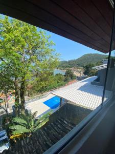 uma vista para uma piscina a partir da janela de uma casa em Casa Sambaqui beira mar em Florianópolis