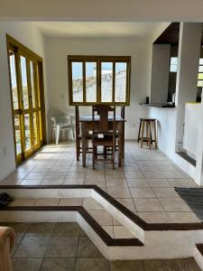 uma cozinha com mesa e cadeiras num quarto em Casa Sambaqui beira mar em Florianópolis