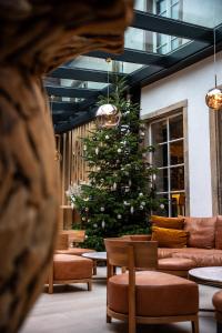 5 Terres Hôtel & Spa Barr - MGallery Hotel Collection في بار: شجرة عيد الميلاد في بهو مع أريكة وكراسي
