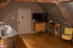 a living room with a flat screen tv and a table at The Archangel,Restaurant & Bar with Rooms in Frome