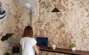 a woman sitting at a desk with a laptop at HOSTEL VALLADOLID 48 in Valladolid