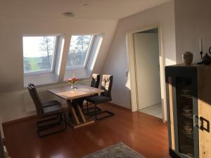 a dining room with a table and some windows at Sonnige Wohnung mit Balkon in Eppingen