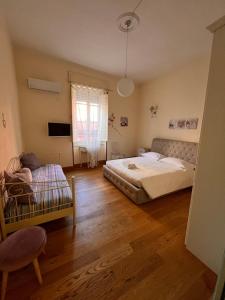 um quarto com 2 camas, uma cadeira e uma janela em Appartamento centro storico Cagliari - Alter Nos house em Cagliari
