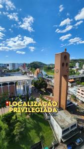 a building with a sign in front of a city at Hotel Europa in Blumenau