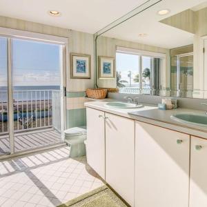 a bathroom with a sink and a toilet and a balcony at Sandglass 4 in Islamorada