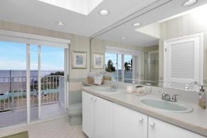 a bathroom with two sinks and a view of the ocean at Sandglass 4 in Islamorada