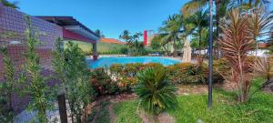 uma piscina num resort com árvores e plantas em COPDS0103 - Condomínio Aldeiotta em Salvador