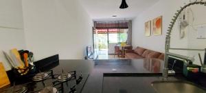 uma cozinha e sala de estar com um lavatório e um sofá em COPDS0103 - Condomínio Aldeiotta em Salvador