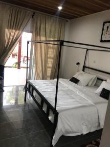 a bedroom with a large bed with white sheets at Natoose Lodge in Saint-Louis