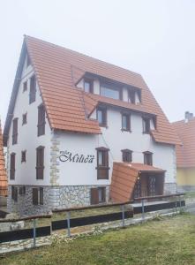 a large white building with a red roof at Vila Milica Apartmani in Kopaonik