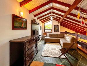uma sala de estar com um sofá e uma mesa em Casa a 180m da Praia do Toque Toque Pequeno SP em São Sebastião