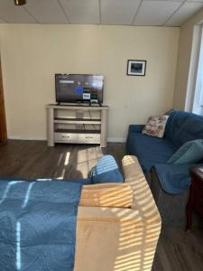 a living room with a couch and a flat screen tv at Comfy Apt near Guthrie RPH Sayre in Sayre